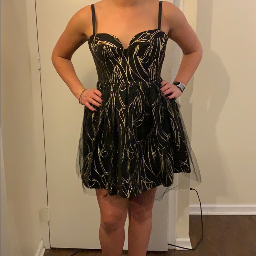 Black cocktail dress with gold embroidery.
